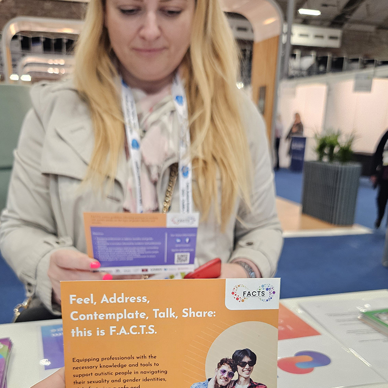 A woman looking at a postcard of the FACTS project